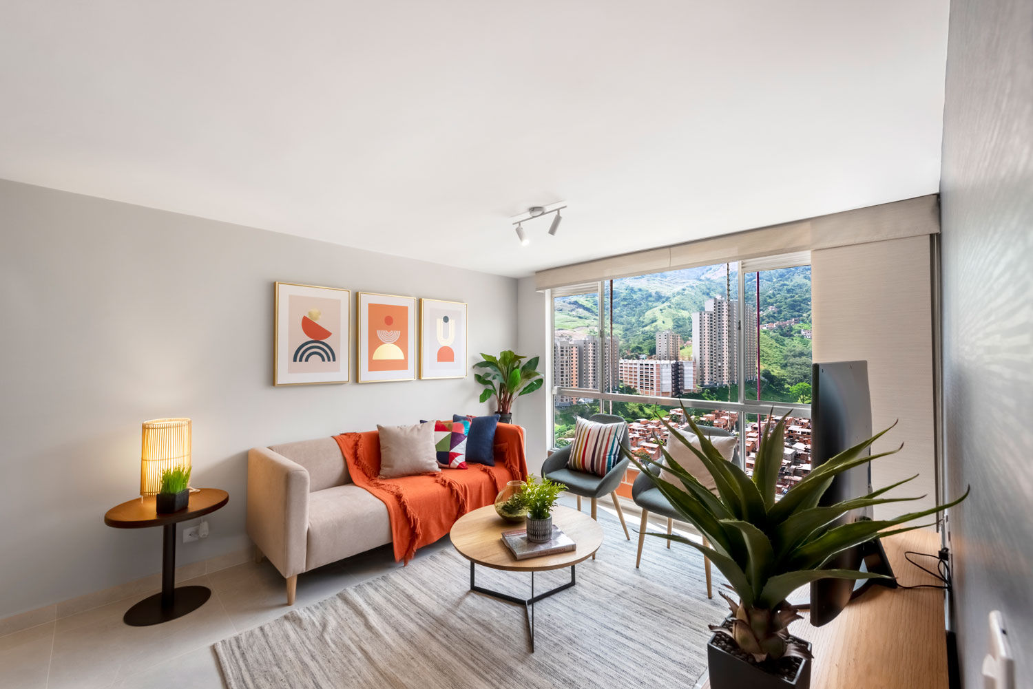 Sala del apartamento modelo de Parque Alto con vista a las montañas y la ciudad.